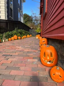 A brick pathway lined with bright orange jack-o'-lanterns, leading along the side of a red house in Salem, MassachusettsA brick pathway lined with bright orange jack-o'-lanterns, leading along the side of a red house in Salem, MassachusettsA brick pathway lined with bright orange jack-o'-lanterns, leading along the side of a red house in Salem, MassachusettsA brick pathway lined with bright orange jack-o'-lanterns, leading along the side of a red house in Salem, MassachusettsA brick pathway lined with bright orange jack-o'-lanterns, leading along the side of a red house in Salem, MassachusettsA brick pathway lined with bright orange jack-o'-lanterns, leading along the side of a red house in Salem, Massachusetts