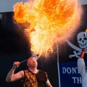 A fire-breather at the Salem Massachusetts Frozen Fire Festival exhaling a burst of flame, creating a brilliant display of heat and light against the evening backdrop.