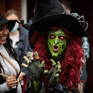 Borah, a costumed witch with green face paint and red hair, captivates visitors in Salem, Massachusetts, with her animated expressions and elaborate attire.