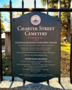 A historical marker at the entrance of the Charter Street Cemetery in Salem Massachusetts, established in 1637, detailing its inclusion in the National Register of Historic Places and providing visitor guidelines.