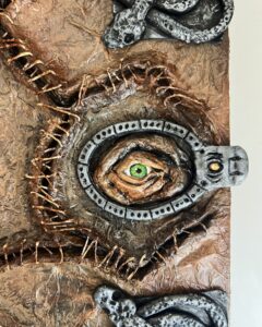 Detailed close-up of a "Hocus Pocus" spellbook replica, featuring a realistic eye surrounded by stitched edges and embossed snake designs in Salem MA