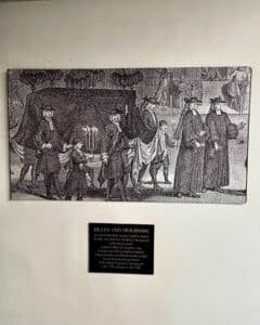Illustration and plaque describing funeral and mourning practices in Salem, Massachusetts, including traditions of mourning gifts and processions.