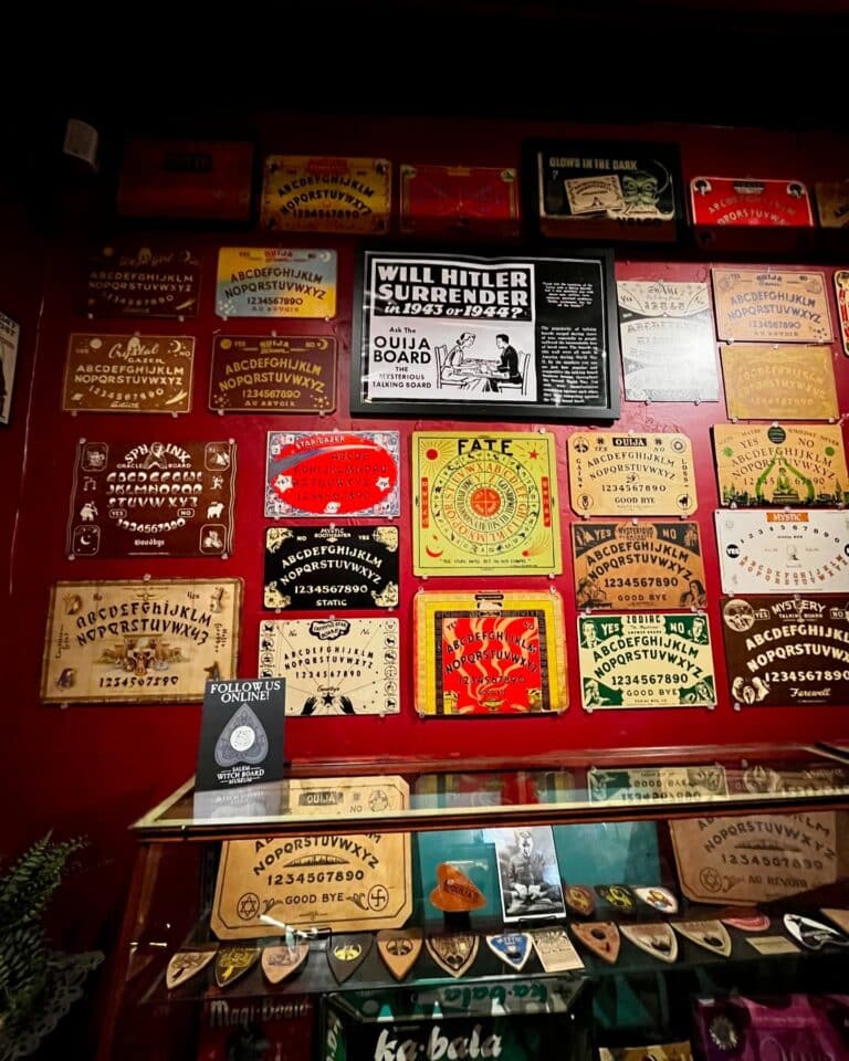 A vivid wall display of historical and artistic Ouija boards at the Salem Witch Board Museum in Salem, Massachusetts, featuring unique designs and intriguing advertisements.