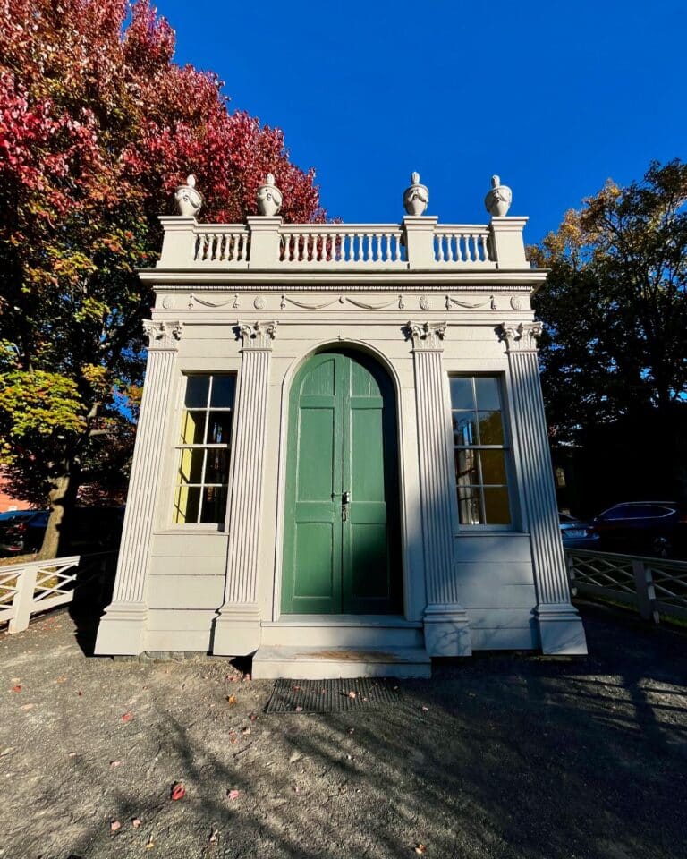 The Derby-Beebe Summer House in Salem, Massachusetts, showcasing its neoclassical design with a green arched door and intricate column details.