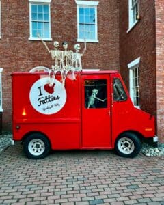 Goodnight Fatty's red food truck adorned with skeletons, parked in historic Salem, Massachusetts.