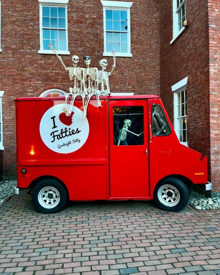 Goodnight Fatty's red food truck adorned with skeletons, parked in historic Salem, Massachusetts.