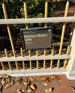 A historical marker for the Hawkes House in Salem, Massachusetts, displayed on a picket fence with the text indicating its establishment in 1780 as part of the Salem Maritime National Historic Site.