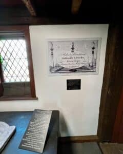 Interior of the historic Pickman House in Salem, Massachusetts, showcasing a sign for Robert Brookhouse, a jeweler from Essex Street, alongside information on early gravestone carvers.