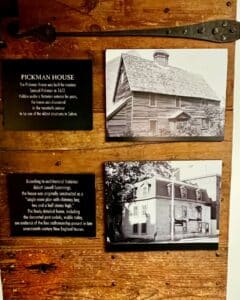 Display at Pickman House in Salem, Massachusetts, featuring photos of the structure's historic architecture and informational plaques detailing its 17th-century origins and restoration.