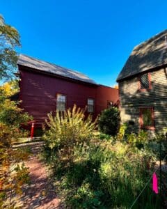 The Pickman House in Salem, Massachusetts, a historic dark green building with diamond-pane windows, located near the Old Burying Point Cemetery.