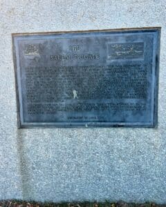 A historical plaque in Salem, Massachusetts, detailing the story of the Salem Frigate, also known as the Essex, a 32-gun ship constructed and launched in 1799, with a significant role in naval history.