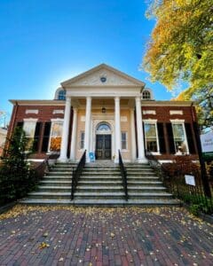 The Salem Athenaeum in Salem, Massachusetts, featuring a historic brick exterior, white columns, and stone steps leading to the entrance.