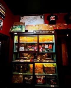 A display case at the Salem Witch Board Museum showcasing Ouija boards, themed merchandise, vintage designs, and branded memorabilia under the banner of the Talking Board Historical Society.