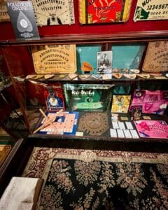 A display at the Salem Witch Board Museum in Salem, Massachusetts, showcasing vintage Ouija boards, planchettes, and divination tools.