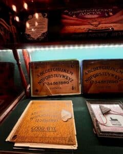 A diverse collection of vintage Ouija boards on display at the Salem Witch Board Museum in Salem, Massachusetts, featuring intricate designs and historical significance.