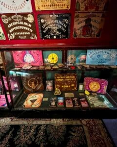 A colorful collection of Ouija boards and mystical tools displayed at the Salem Witch Board Museum in Salem, Massachusetts, featuring intricate designs and an array of related items.