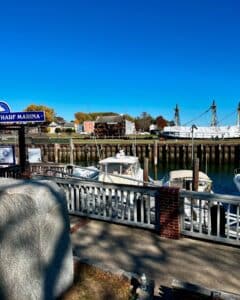 Salem waterfront in Massachusetts with the Friendship of Salem ship, docked boats, and historic buildings under a clear blue sky.