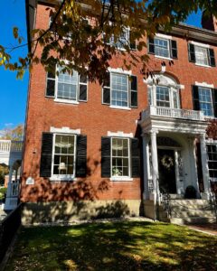 The William Pickman House, a historic red brick home in Salem, Massachusetts, with black shutters and a white columned entrance.
