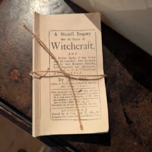 A reproduction of "A Modest Enquiry Into the Nature of Witchcraft" by John Hale, tied with twine and displayed on a wooden table in Salem, Massachusetts.