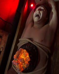 A mannequin tied down with a simulated rat cage containing glowing embers on their torso, part of the rat torture exhibit at the Salem Museum of Torture in Salem, Massachusetts.