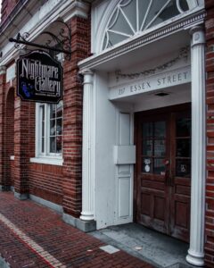 The brick exterior and classic columns of Count Orlok's Nightmare Gallery on Essex Street in Salem, Massachusetts, showcasing its spooky and mysterious sign.