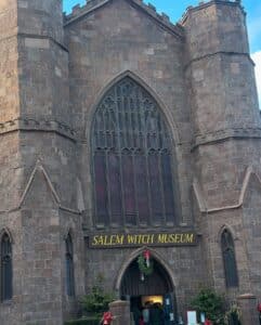 The Salem Witch Museum in Salem, Massachusetts, features gothic-style stone walls, arched windows, and a large entrance decorated with holiday wreaths.