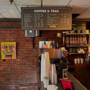 Coffee bar with a menu board and art on the wall at Front Street Coffeehouse in Salem Massachusetts