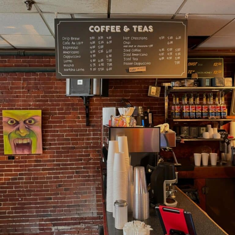 Coffee bar with a menu board and art on the wall at Front Street Coffeehouse in Salem Massachusetts