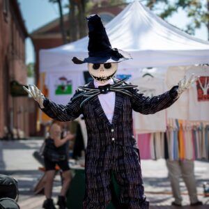 Jack Skellington, the beloved character from The Nightmare Before Christmas, dressed in his iconic striped suit and witch hat, delighting visitors during a festive outdoor event in Salem, Massachusetts.