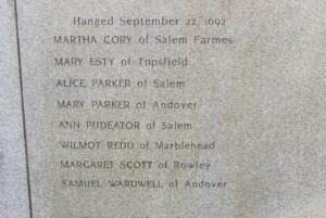 A close-up view of an engraving at a Salem memorial listing the names of those hanged on September 22, 1692, during the Salem witch trials.