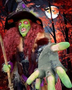 Borah the witch in Salem, Massachusetts, with green skin, fiery red hair, and a pointed hat, reaching forward under a glowing full moon with bats flying in the background.