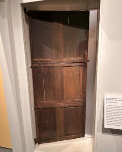 An old wooden door from salem massachusetts with carved borders and a simple latch, dating back to the 17th century.