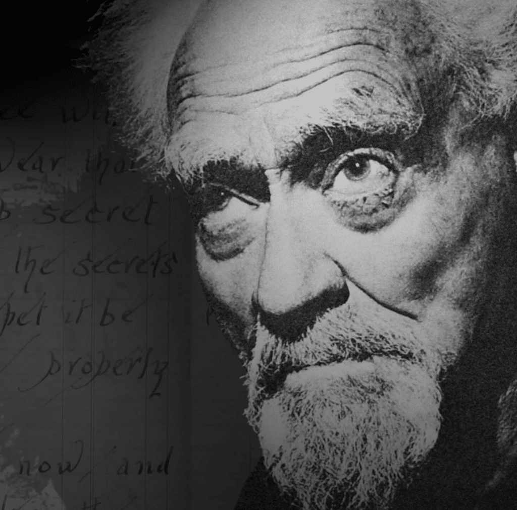 A black-and-white portrait of Gerald Gardner, often referred to as the "father of modern Wicca." The close-up image highlights his intense gaze and distinctive features, including a weathered face and white beard, conveying wisdom and a sense of mystery. In the background, faint handwritten text adds an aura of historical significance and connection to his work in reviving and shaping modern Wicca.
